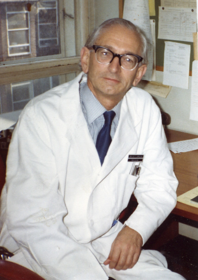 GFJ at desk wearing white coat