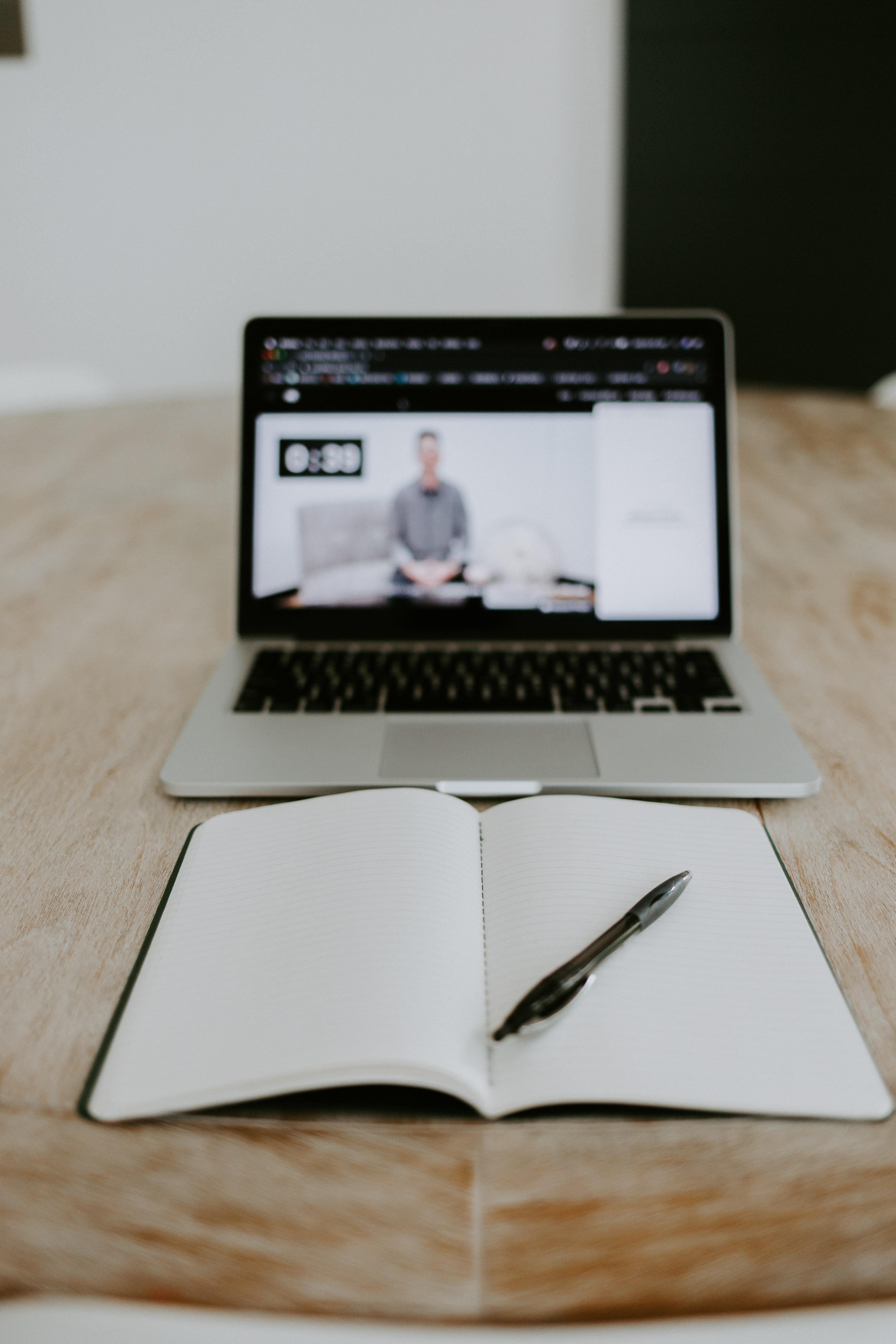 An open book in front of a laptop showing an in-progress lecture.